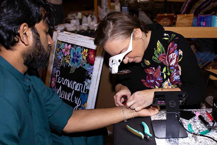Michelle Welsh welds a bracelet onto Lexington resident Paul Haroon during an event at the Wrigley Center in Port Huron on Saturday, Jan. 13, 2024.