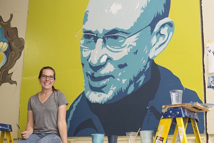 Laura Collins-DeNault and her artwork honoring the late David Korff, her friend and mentor who was an active member of the art community in the Blue Water Area.