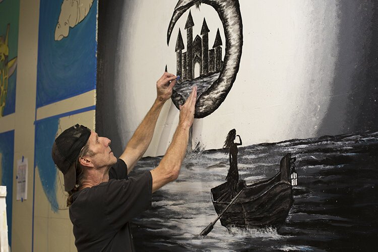 Artist Allen Scott (aka Scott E. Skullz), does detail work on his mural.
