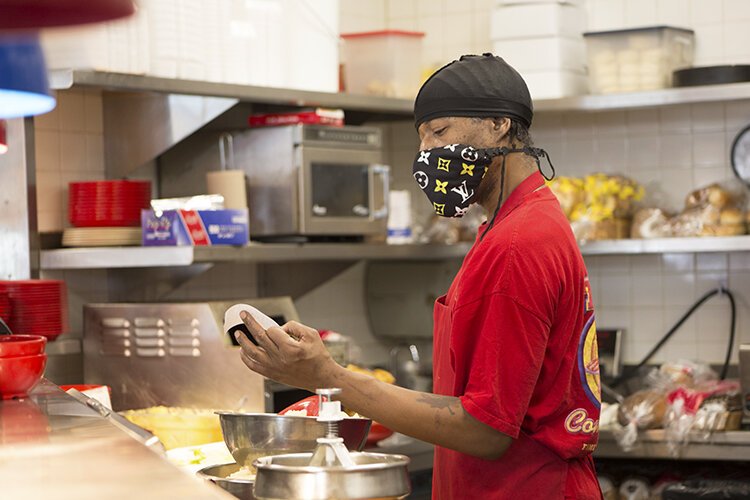 Darnell Horne, a cook at Ted's Coney Island in Port Huron, reads a ticket before preparing an order.