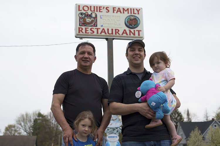 Founder of Louie's Family Restaurant Louie Dimoski (left) poses for a photo with his grandchildren Naudia (left) and Evelyn, and his son Jason Dimoski who is the general manager of the restaurant.