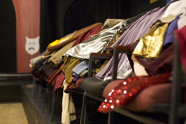 While the costume rooms at the Richmond Community Theatre undergo a renovation, costumes are draped over chairs on the stage for safekeeping.