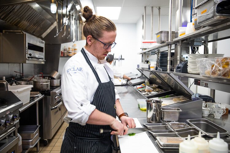 Chef Jacob Verstegen works at a station in the kitchen.