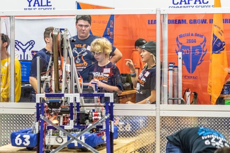 The Yale Robotics team works with its robot.