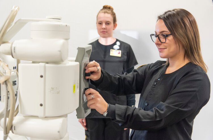 Students practice taking X-rays on a portable machine.