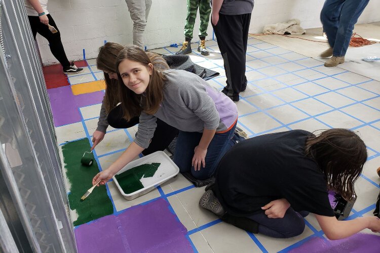 Teens paint the floor of the River Rec Teen Zone in Marine City.