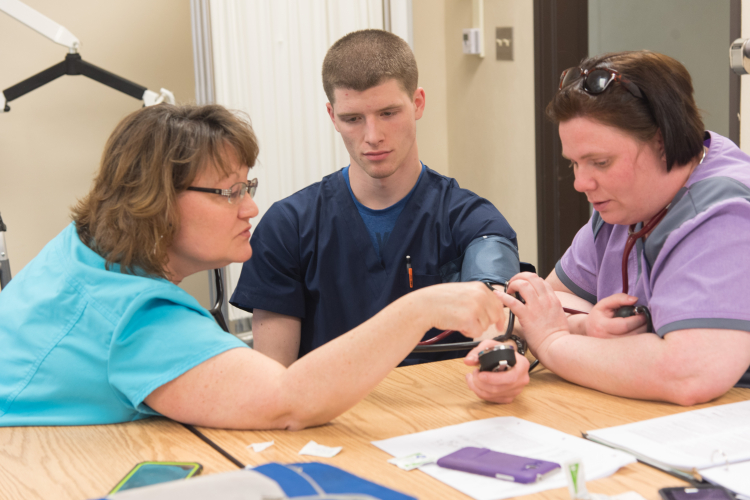 Students practice skills needed to become a certified nurses aide.