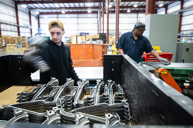 Team members work at their stations at PTM Corp.