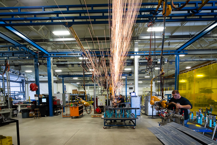 Sparks fly as employees work on stamps at PTM Corp.