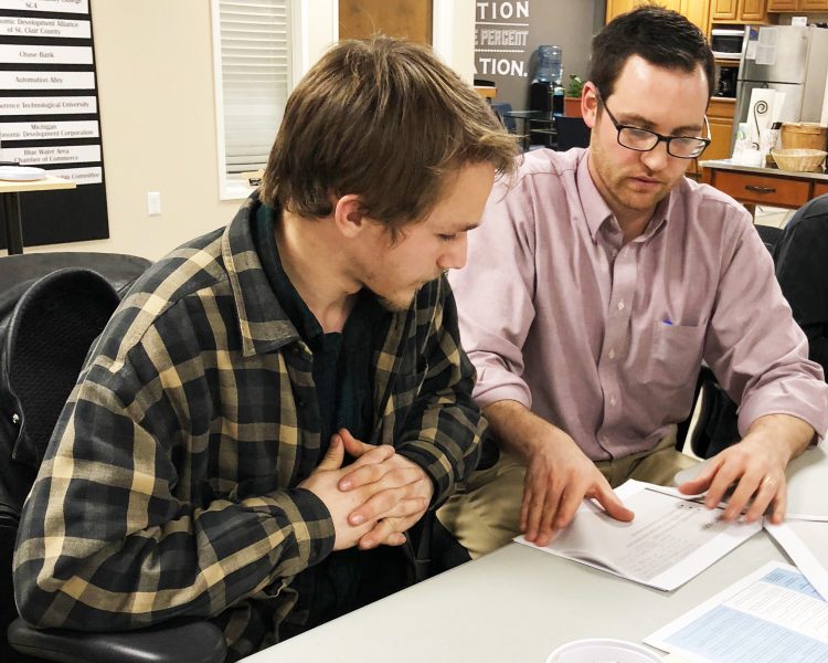 Quentin Bishop helps a student with his business plan.