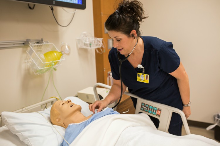 Sherry Graham checks vital signs on a dummy in the St. Clair County Community College simulation lab.