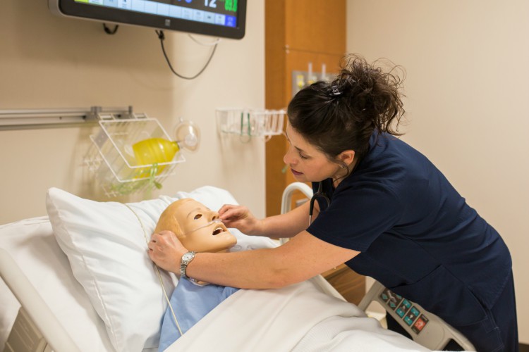 Sherry Graham practices applying a nasal canula to her simulation patient.