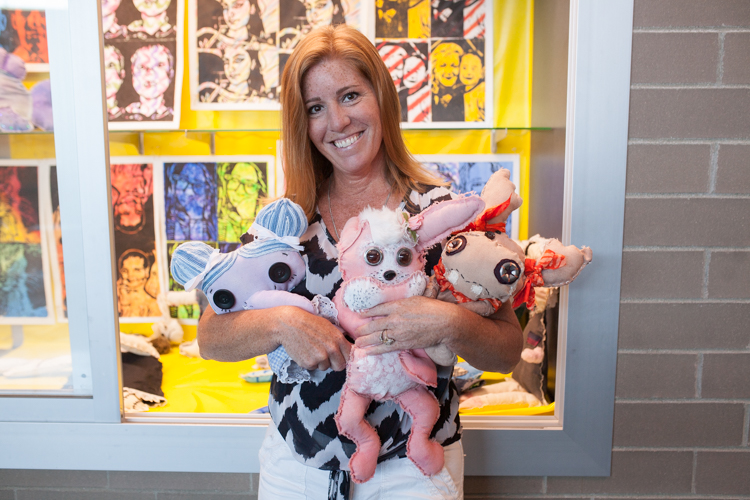 Joannie Roehl shows off Creepy Dolls created by her art students. Photo by Heather Burt.