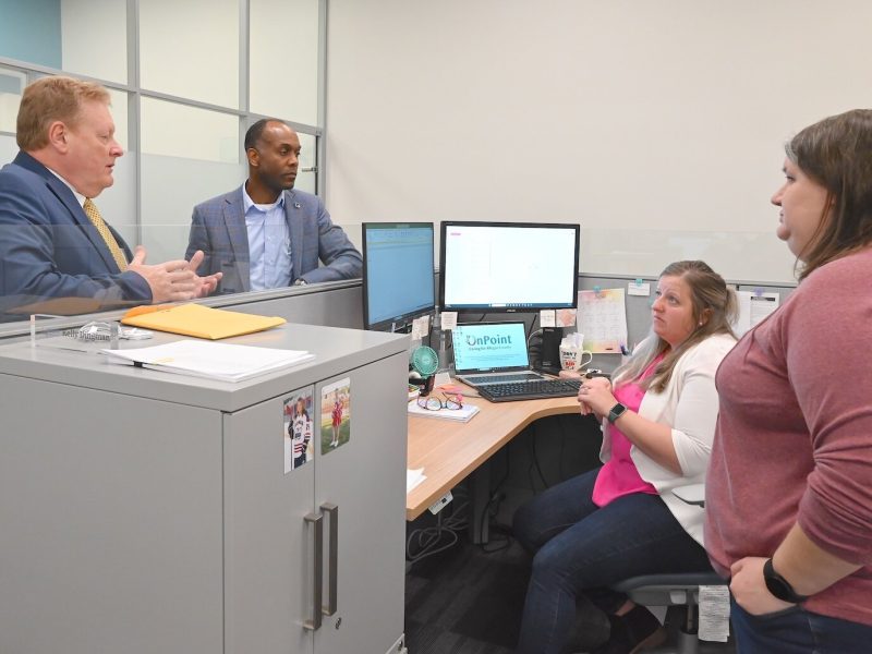 Mark Witte chats with OnPoint staff: from left, Andre Pierre, Jr., chief administrative officer; Kelly Dingman, accounting supervisor, and Sarah Lumbert, general accountant.