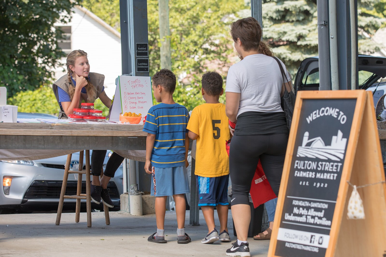 A Farmers Market Food Navigator assists shoppers at the Fulton Street Market in Grand Rapids.