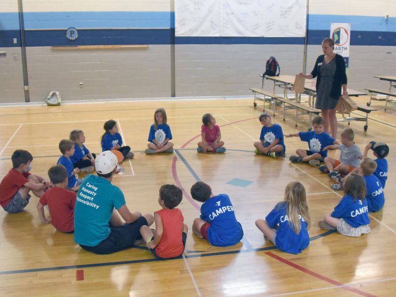 Campers at the YMCA summer day camp at Petoskey's Ottawa Elementary School play a game, hosted by Health Department of Northwest Michigan staff, in which they try to guess what fruit or vegetable is in a bag without looking.