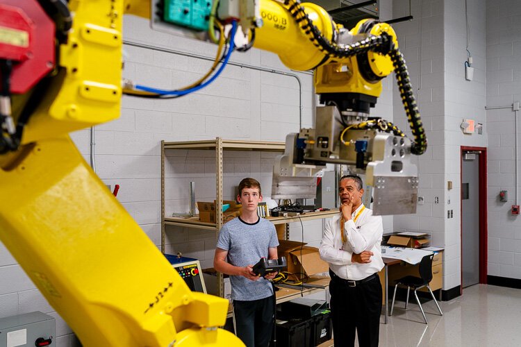 Cleveland Sparrow (right) with a student working with a robot.