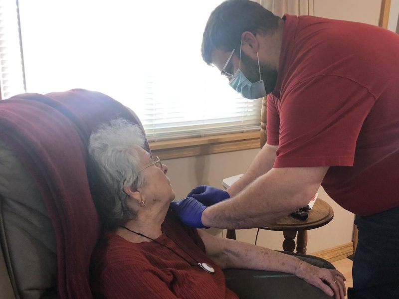 Nathaniel Bergman administers a COVID-19 vaccine to a homebound resident in her home.